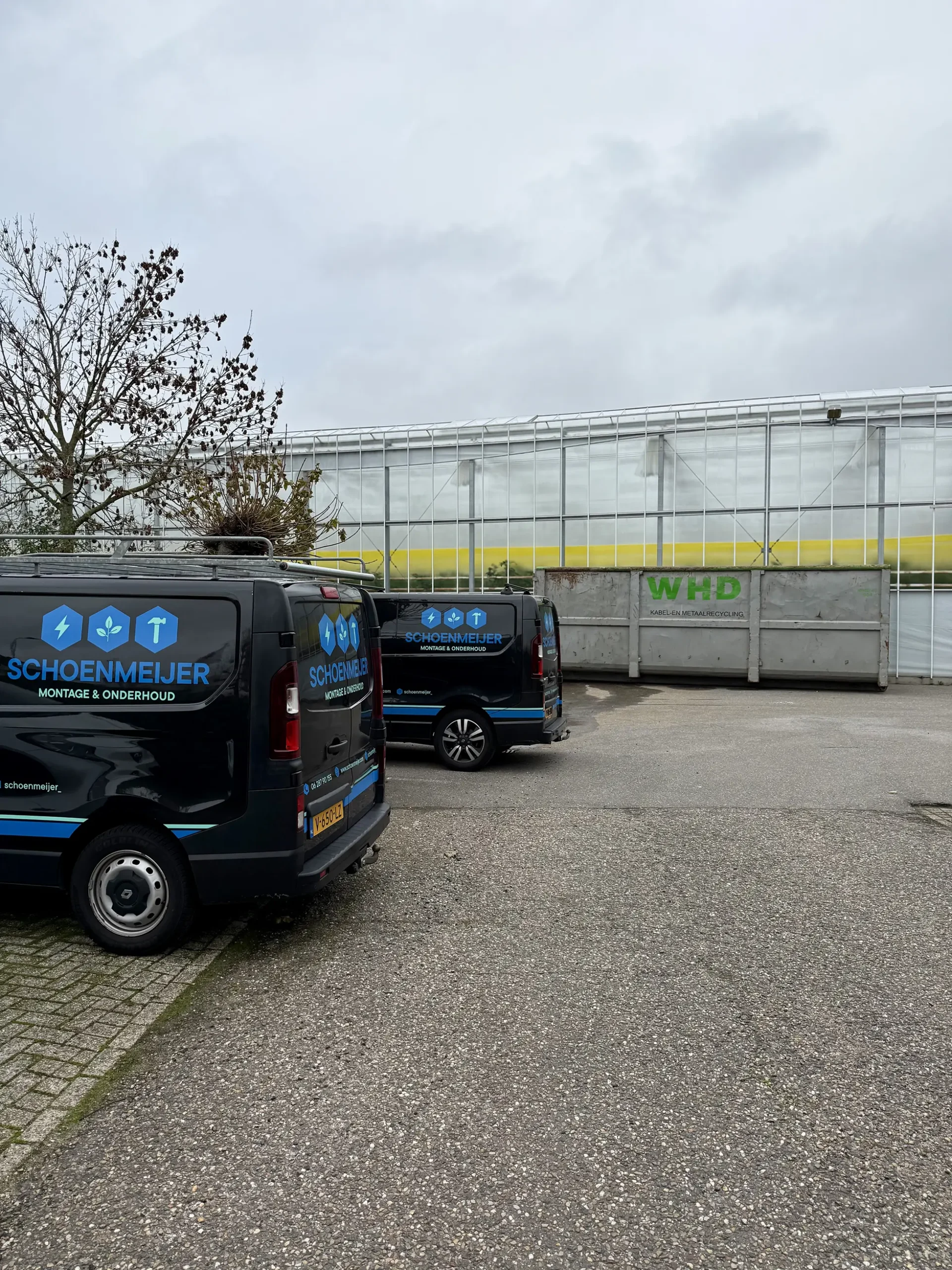 Bedrijfsbussen van Schoenmeijer bij een kas